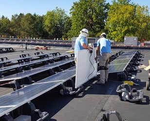 Paradise Energy installers working on a ballast mount solar system