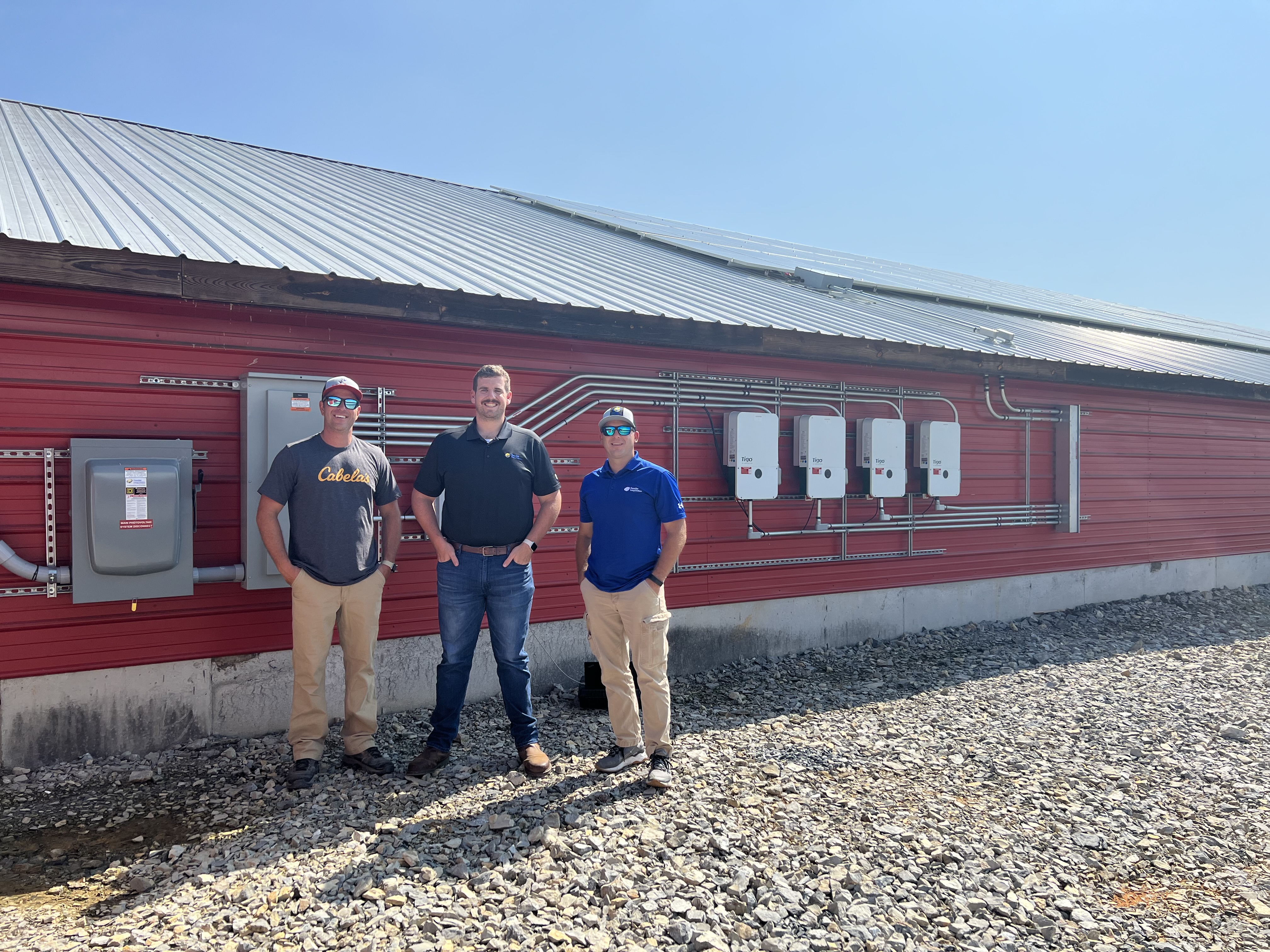 Alex Botkin and Paradise Energy Solutions team at his poultry farm in front of his roof mount solar array.